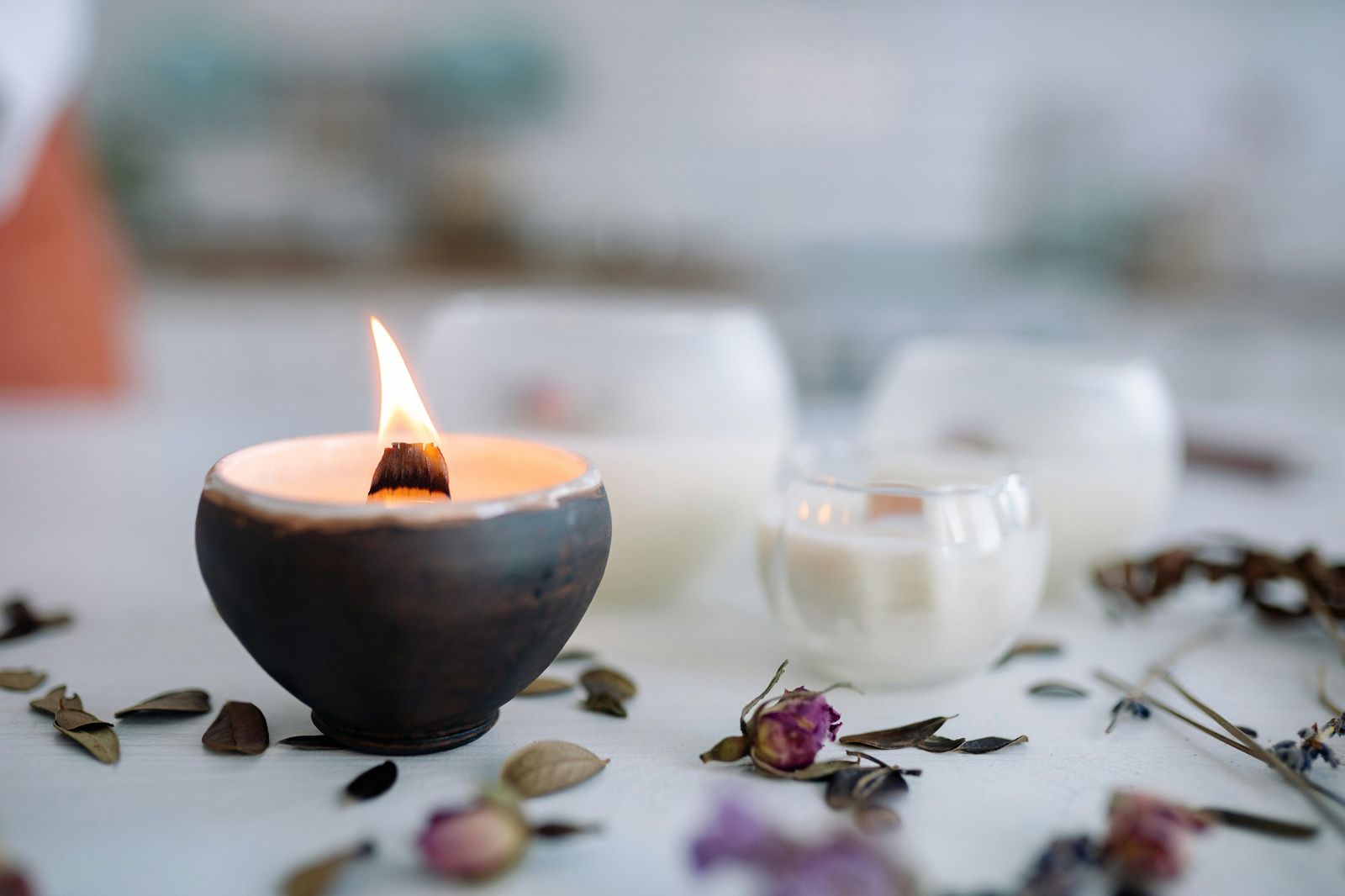 A lit candle with dried rose petals