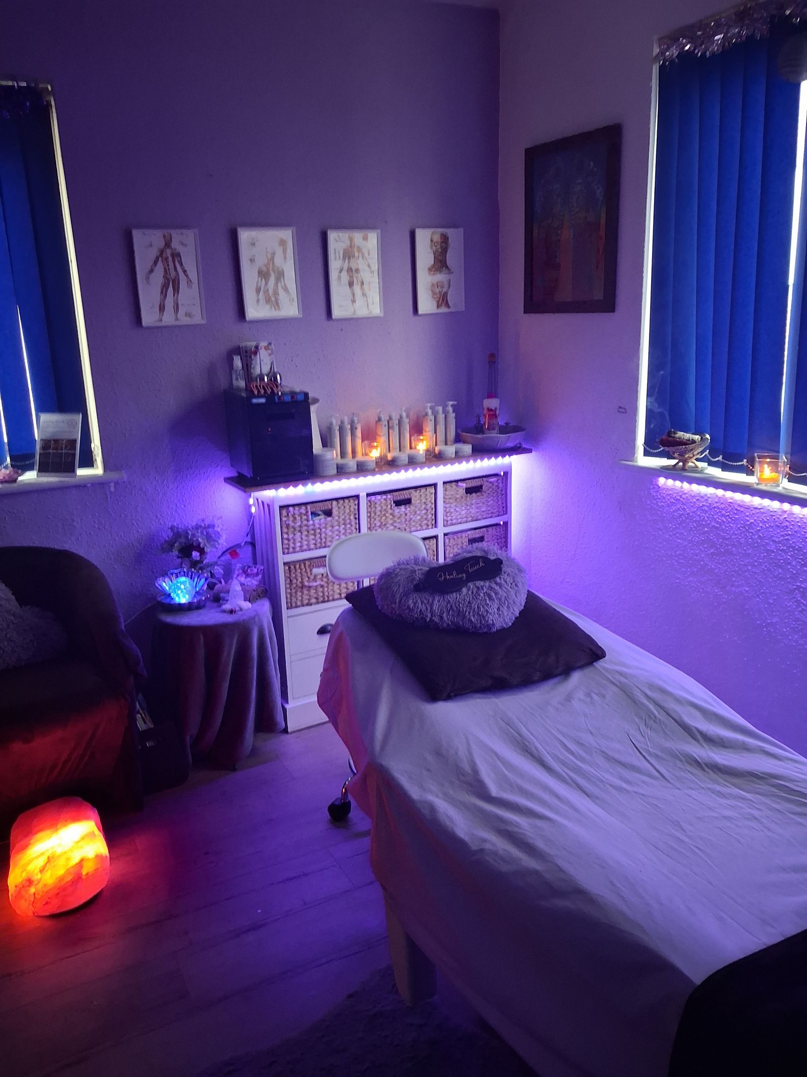 The Healing Touch treatment room, softly lit in purple with candles and a salt lamp